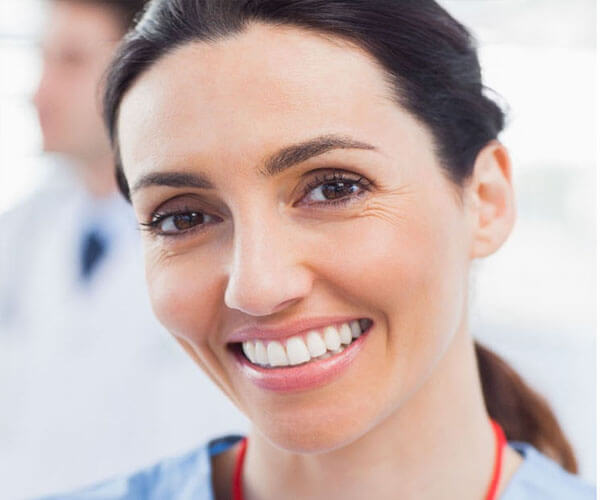 Close up picture of a dentist smiling back at the camera